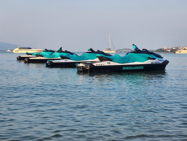 Four turquoise Sea-Doo GTX jet skis floating together on glassy water off Koh Samui at first light