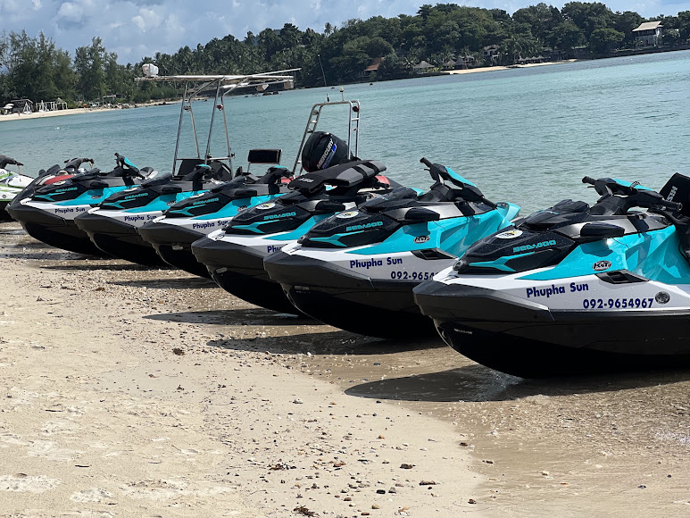 Turquoise and white Sea-Doo jet skis lined up on the sand at the SunJetski beach in Koh Samui